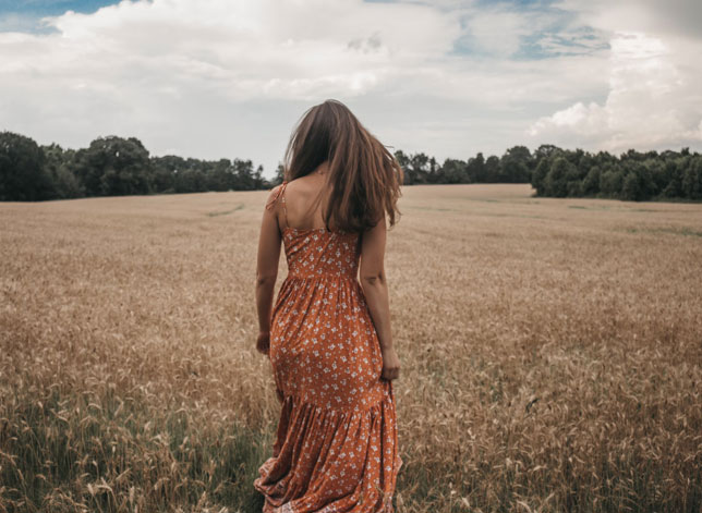 Fotografía de una mujer de espaldas en un campo